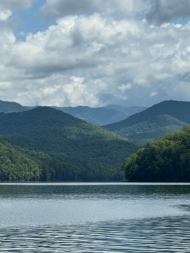 A calm lake with a view of the mountains in the background.