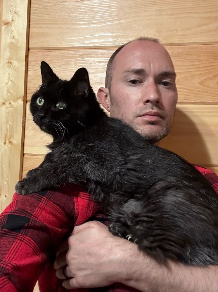 Vance holding the same black cat, now twenty years old.