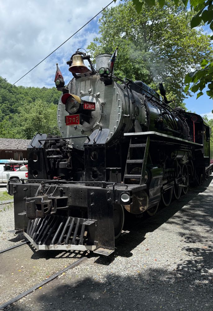 An old steam engine sitting on train tracks.