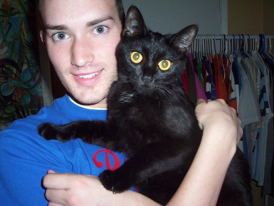 Vance holding a one-year-old black cat.