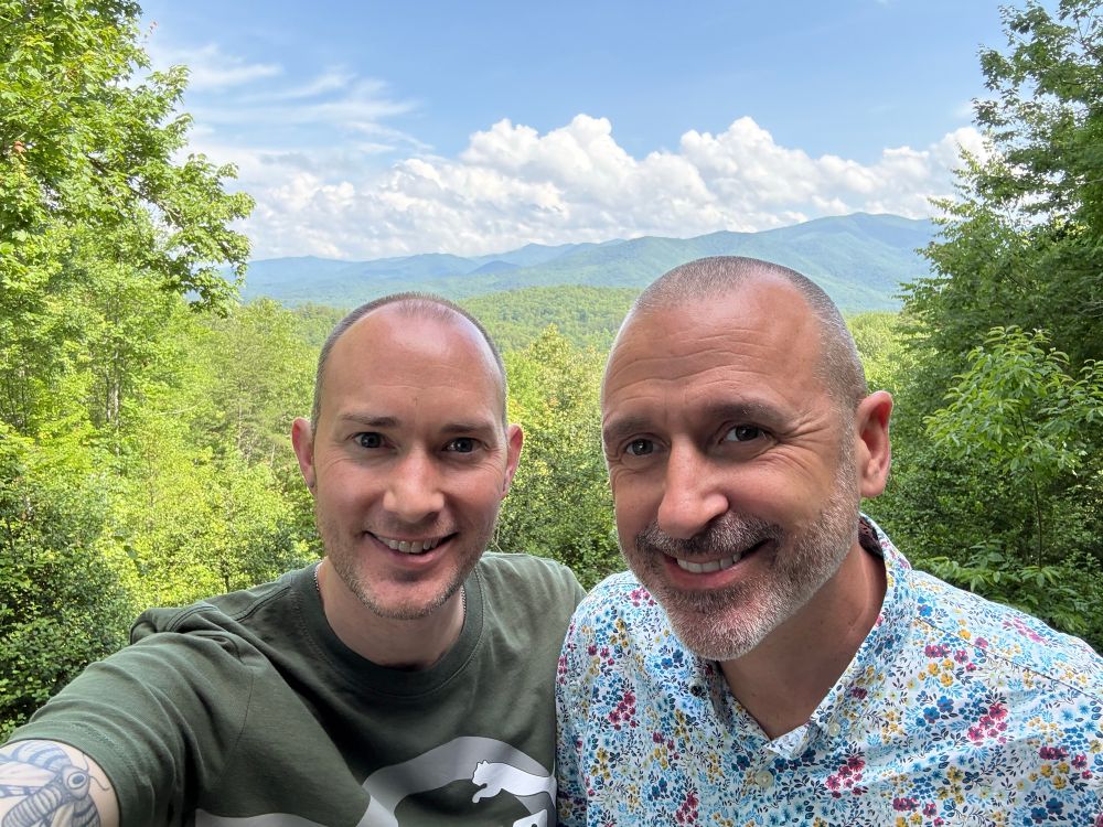 Two people standing in front of a Mountain View.