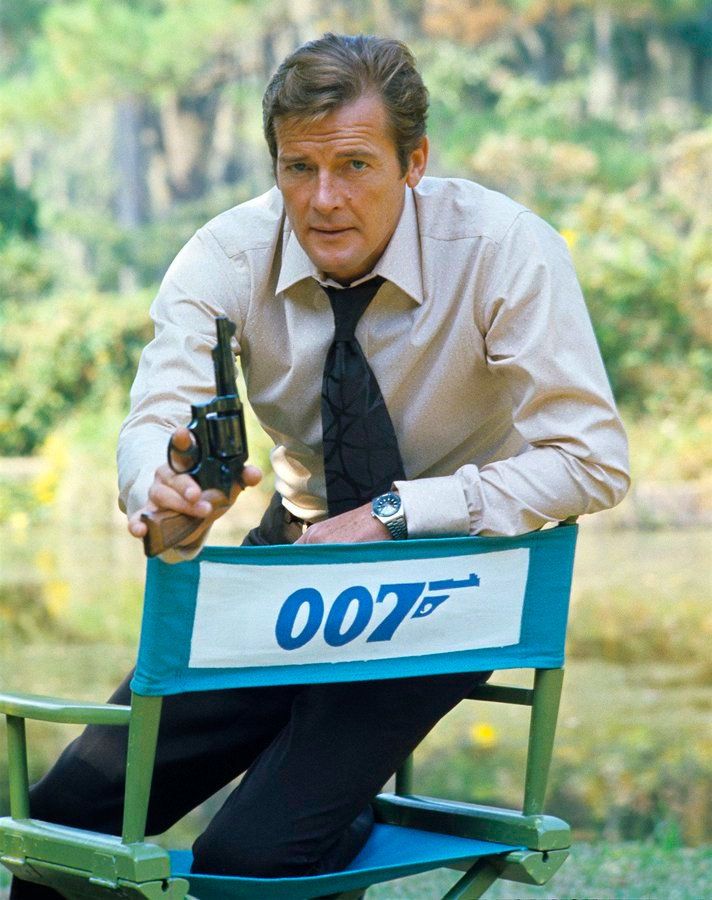 LIVE AND LET DIE promo pic of Roger Moore sat awkardly in a chair with 007 written on it