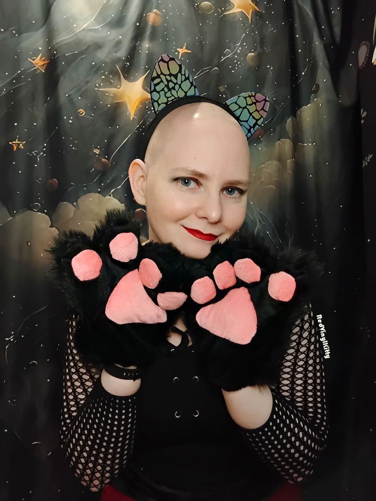 Kitty holds up two paws with soft squishy toebeans on them.