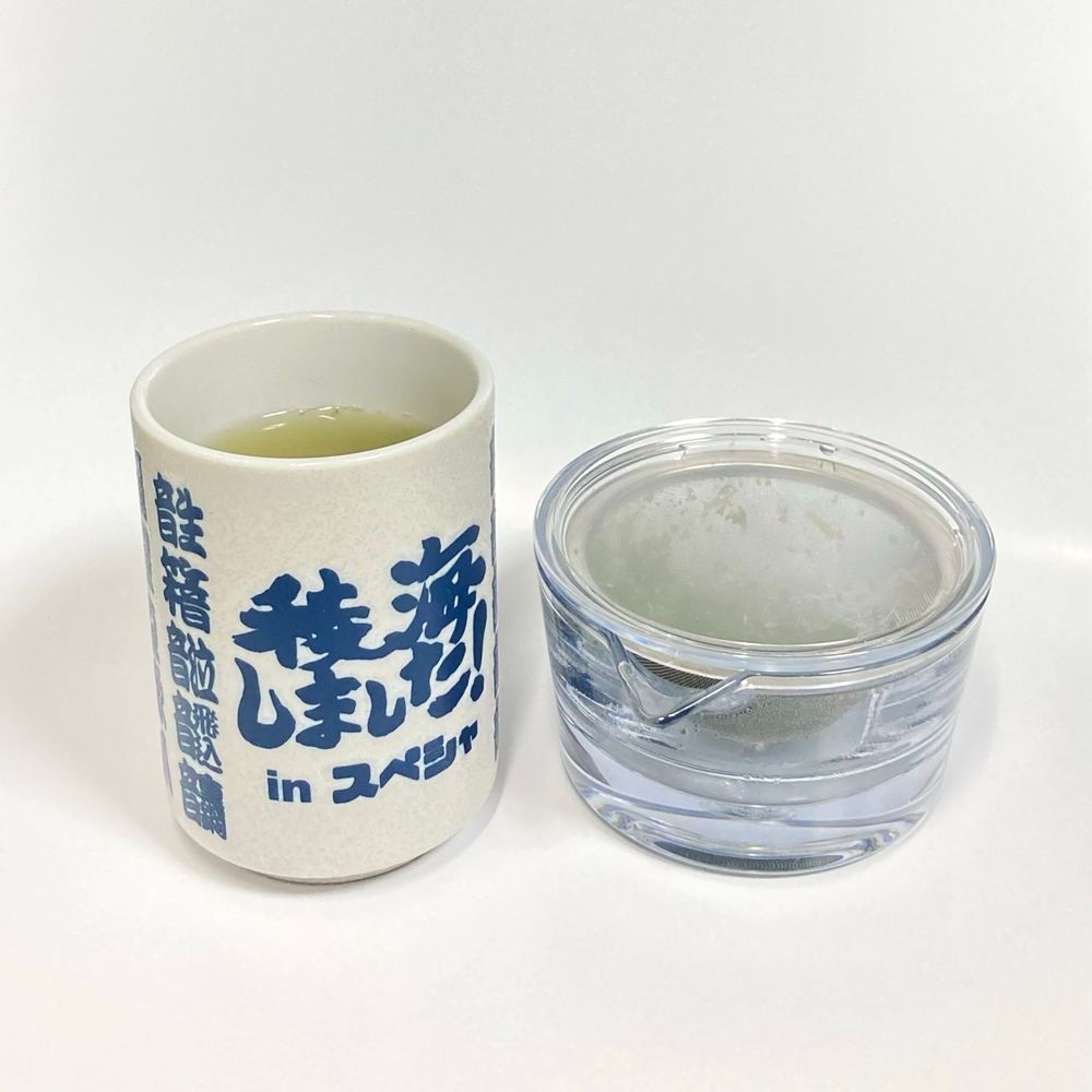 写真の左側に湯呑み、右側に透明の急須。
湯呑みの真ん中には筆で書かれた文字『稜海しました！inスペシャ』が配置されている。