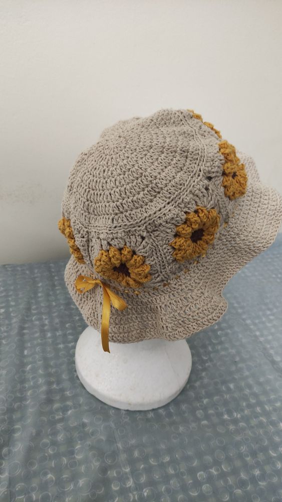 Chapéu com girassóis feito de crochê. Feito com linha crua, amarela e marrom.