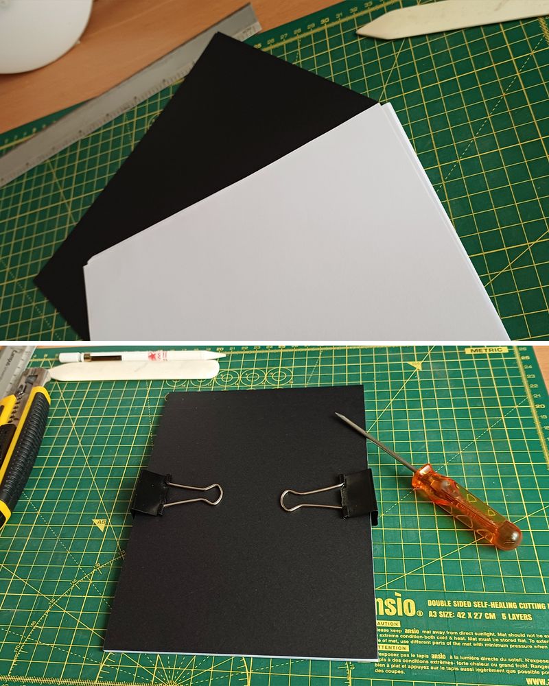 Photos of said steps with the top being paper and black cardboard over a green cutting mat, and the bottom being those papers trimmed and clipped to pierce them