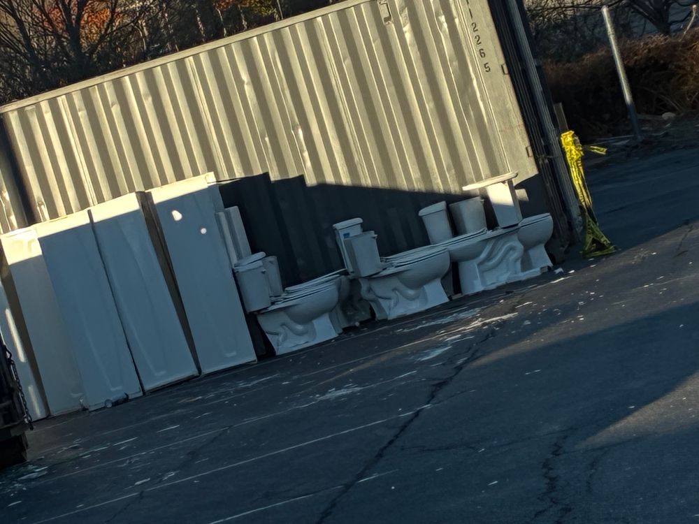 A bunch of toilets in a parking lot 