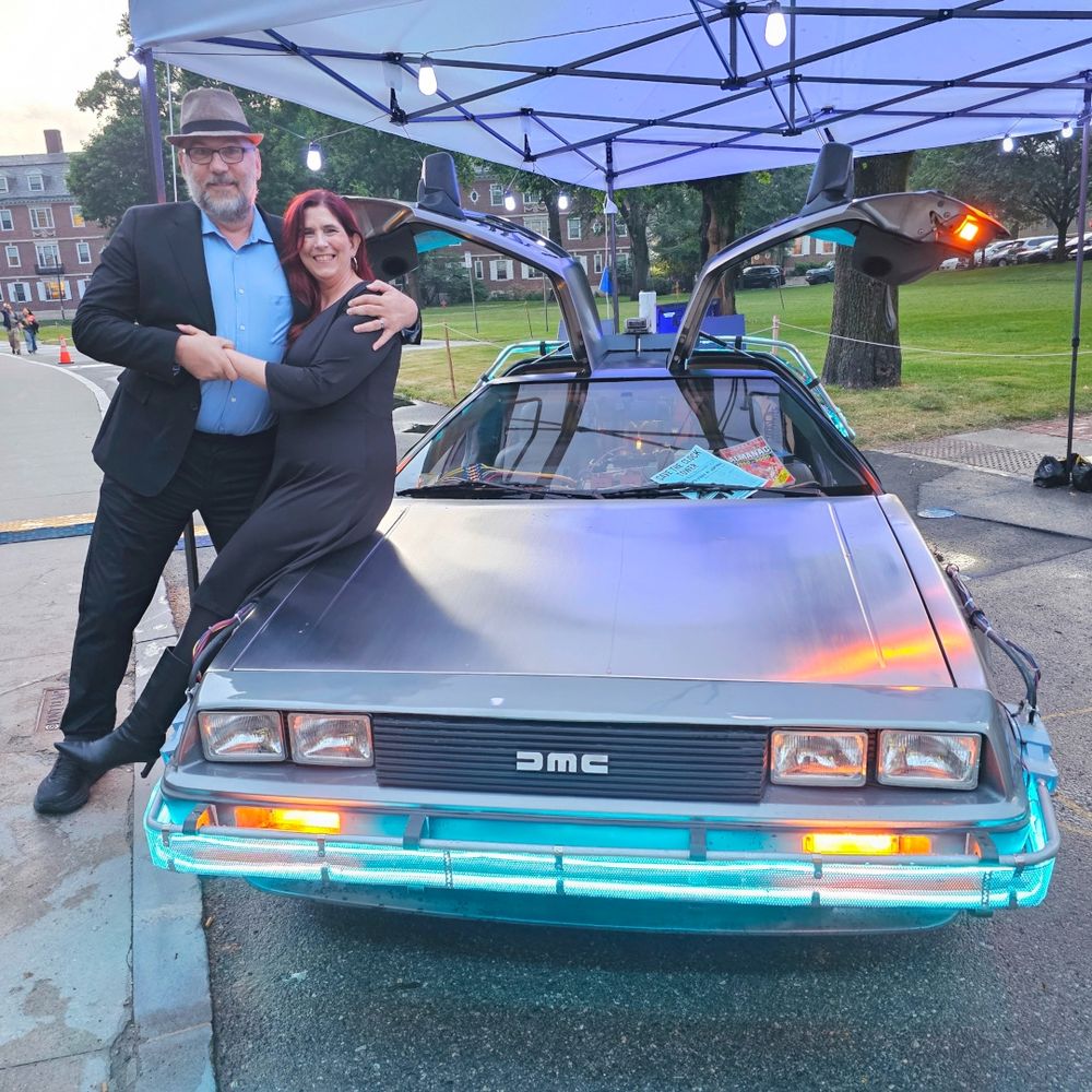 Technodad and Demeter leaning against the Back to the Future Delorean.