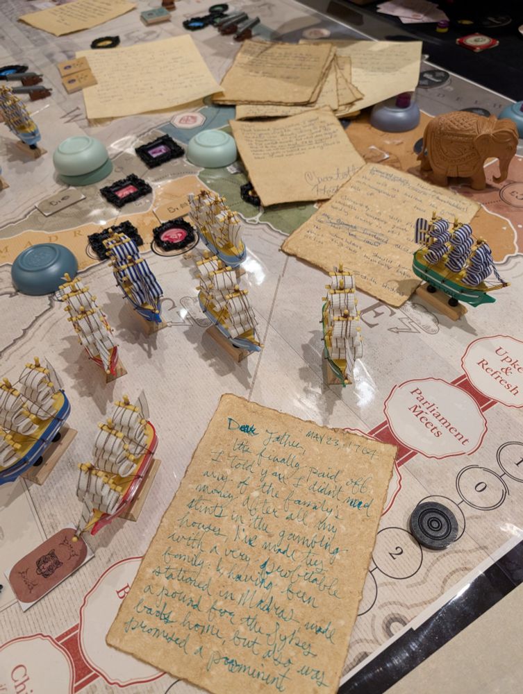 Photo of giant John Company with model boats and custom DIY pieces. Hand written Letters strewn about from the Company Archives TTRPG session at Gen Con 2025