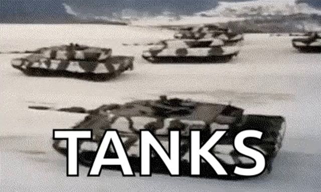 a black and white photo of a row of tanks driving through the snow .