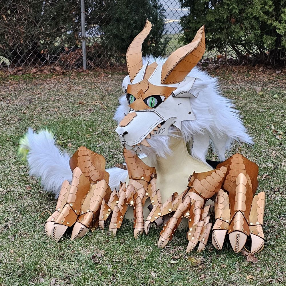 A white and gold dragon partial including the head, claws, feet, and a tail 