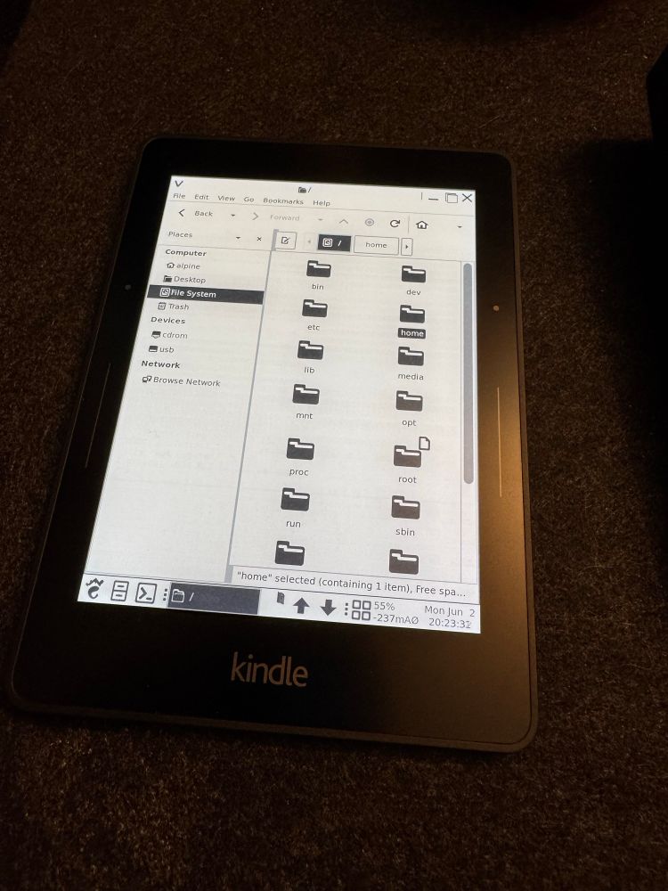An Amazon Kindle Voyage displays a Linux MATE desktop with a filebrowser open.