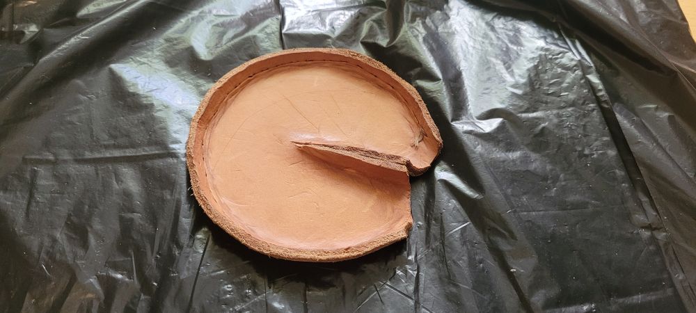 A disk of leather roughly shaped to resemble the bottom of a horses hoof