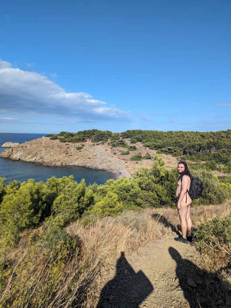 The same composition as the first picture, but I'm a little further down the path and glancing at the camera with a smile, overlooking the sea.