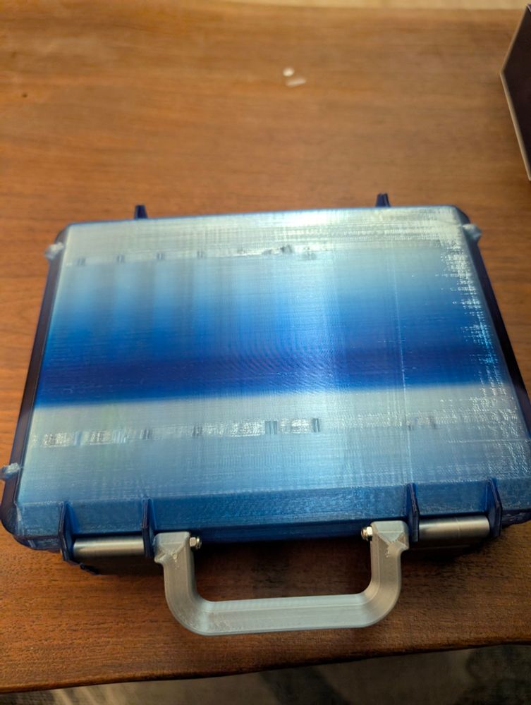 A shiny blue gradient briefcase style box with silver handle and latches