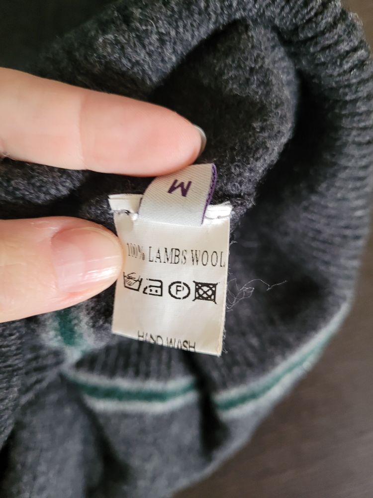 Pflegezettel des Pullis: 100% Lammwolle, nur Handwäsche, Größe M