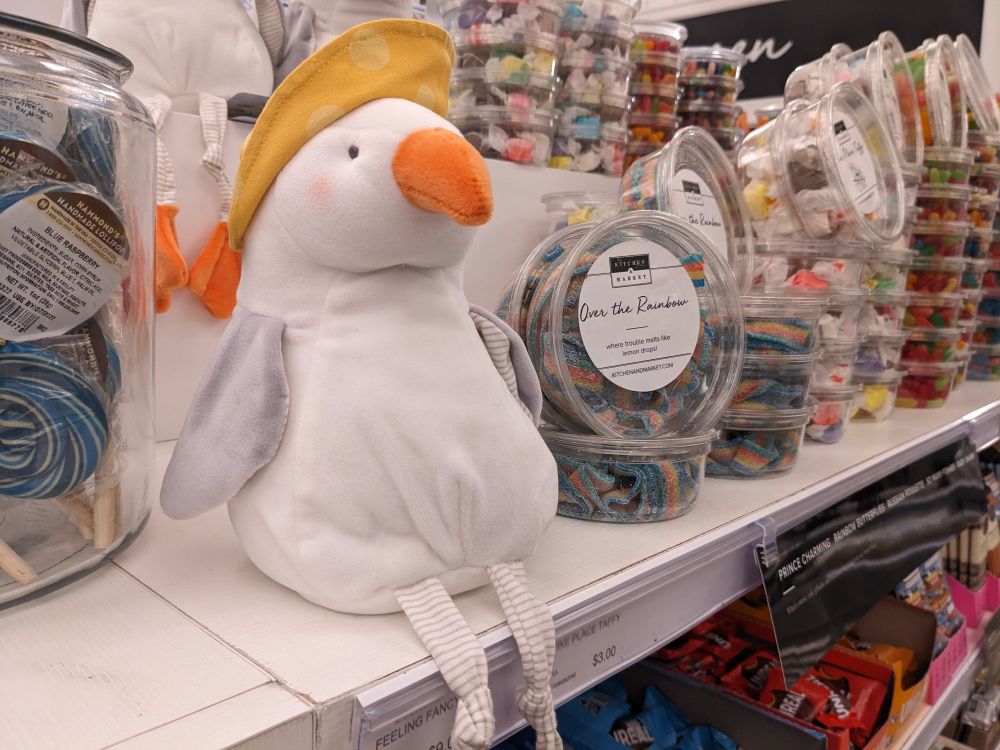 Seagull plush sitting in aisle of candy 