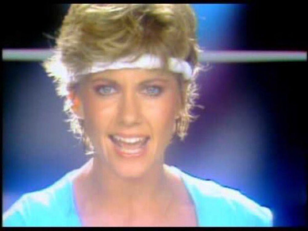 Color still of ONJ wearing colorful workout gear in the video for “Physical.”