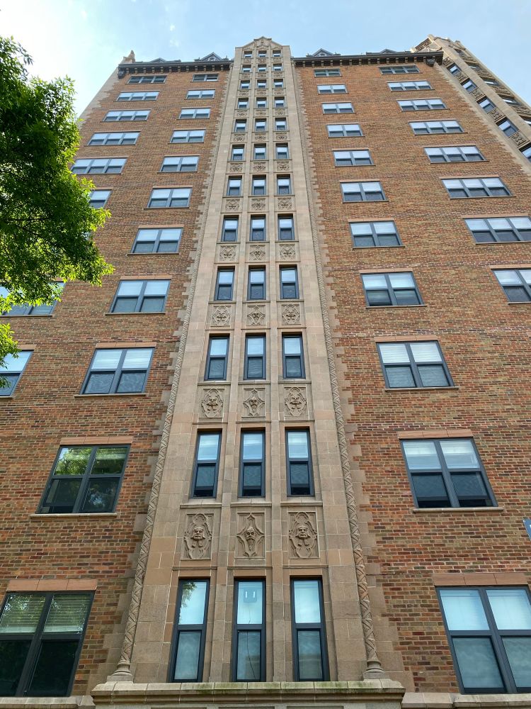 A vertical view of the farcroft building, an array of grotesques climbing up its front facade 