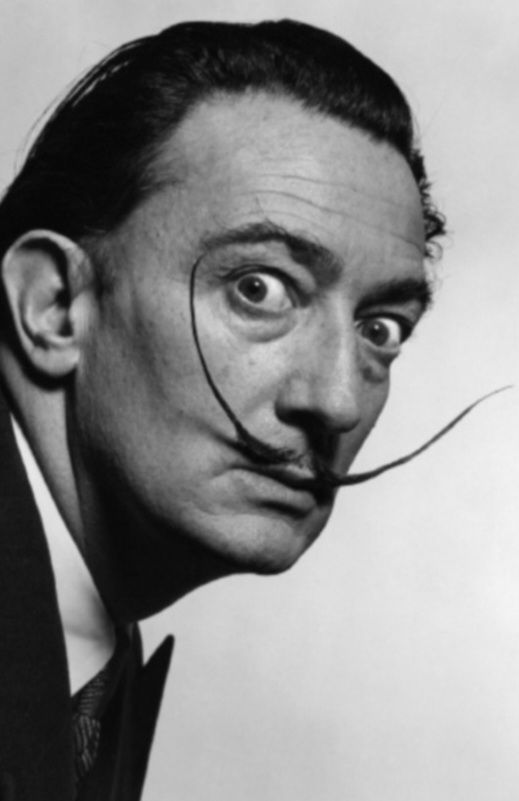 A well-known black and white photo of Salvador Dali, with wide eyes and his trademark twirly moustache 