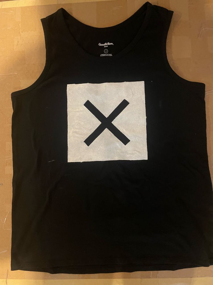 A thrifted black tank top with a black x inside a white square 