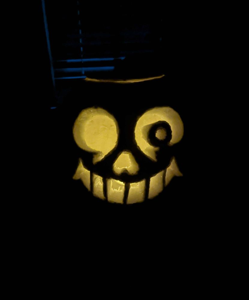 A pumpkin carved in Sans' likeness, but this time in the dark to get a clearer image of his face. Spooky...