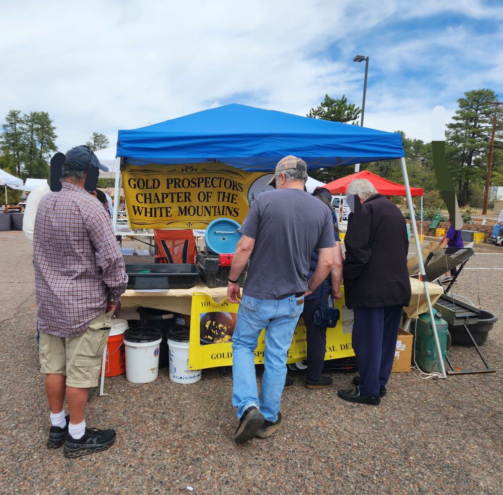 A picture of the booth for the Gold Prospectors Chapter of the White Mountains surrounded by several older adults