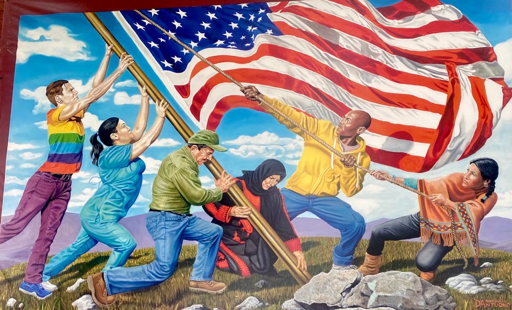 Six people very much not fitting the straight white male stereotype putting up an American flag.