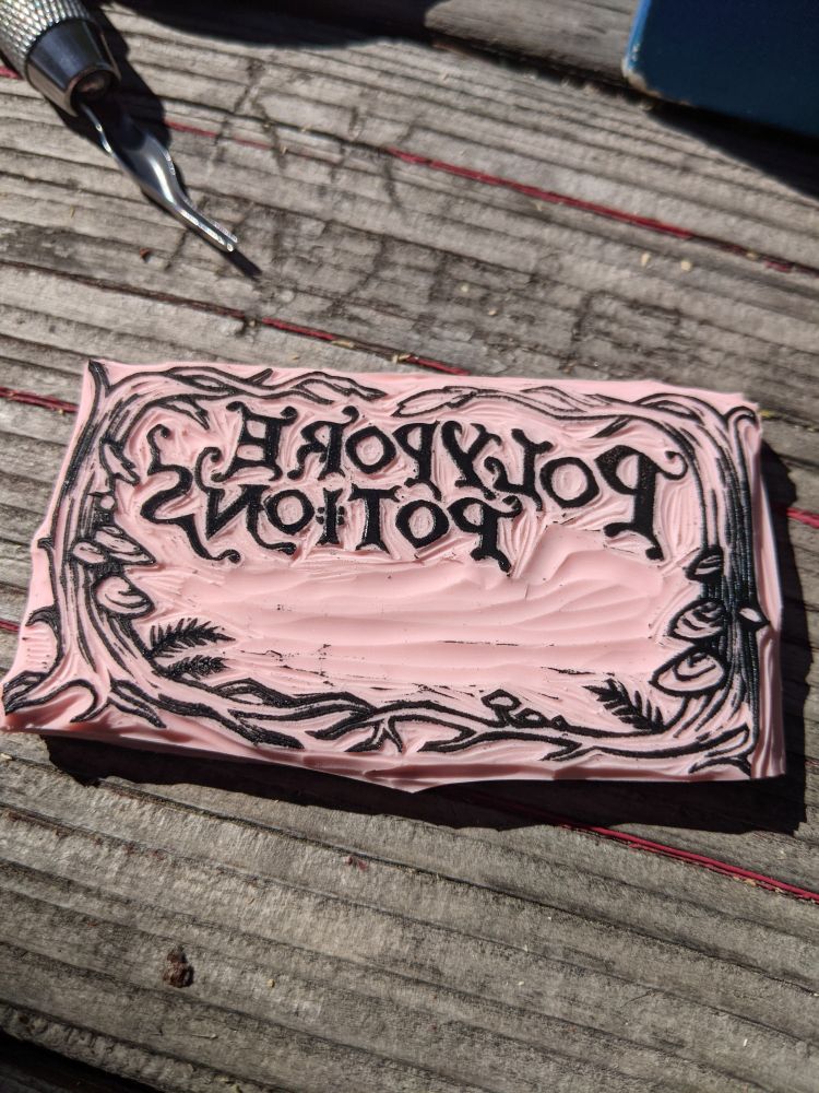 A photo of a freshly carved label stamp to be used for tincture bottles, the lettering says polypore potions