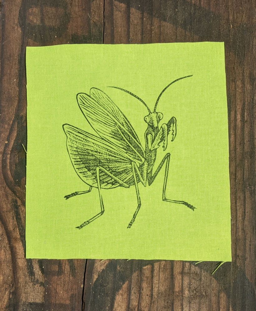 Mantis with their wings spread linocut on lime green fabric