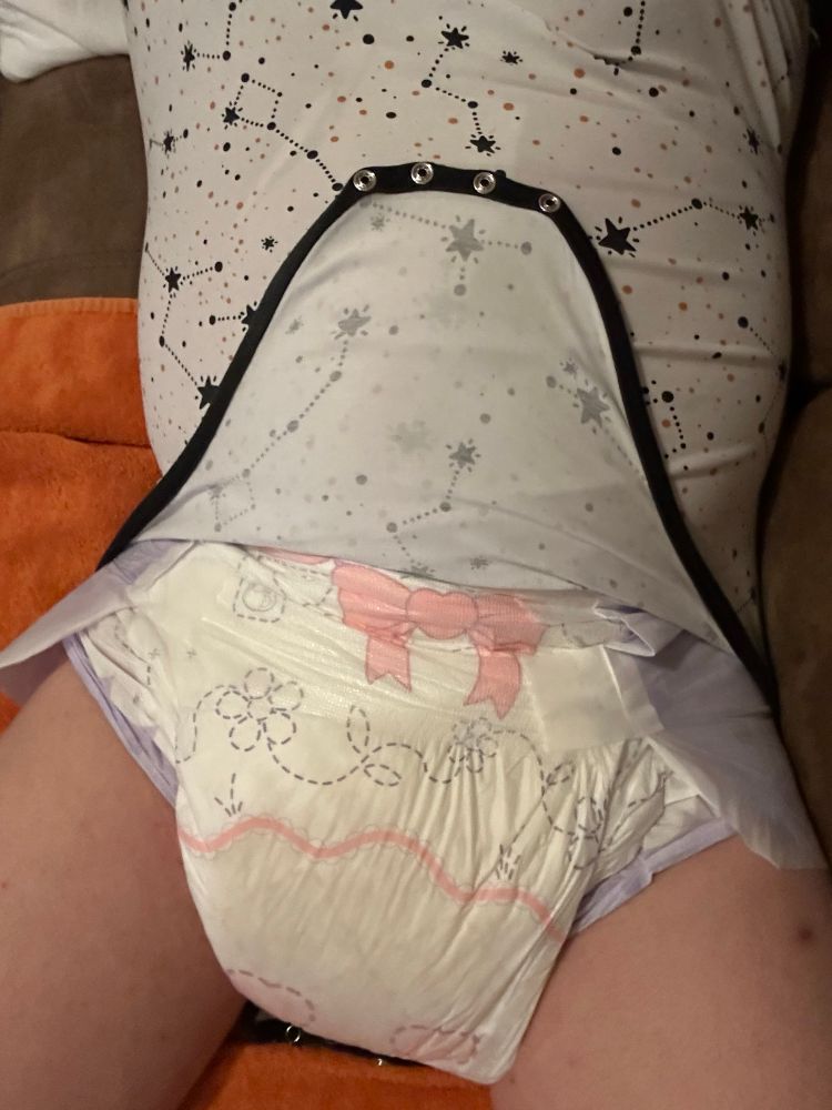 Onesie snaps undone, showing off the soaked lacy loves diaper underneath 