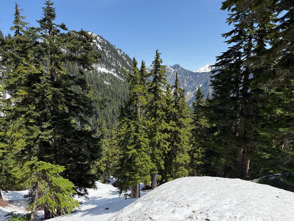 Snow covered hiking trail with mountains in the background.
