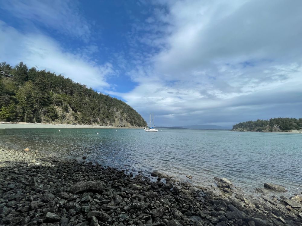 Pacific Northwest beach with a boat at anchor