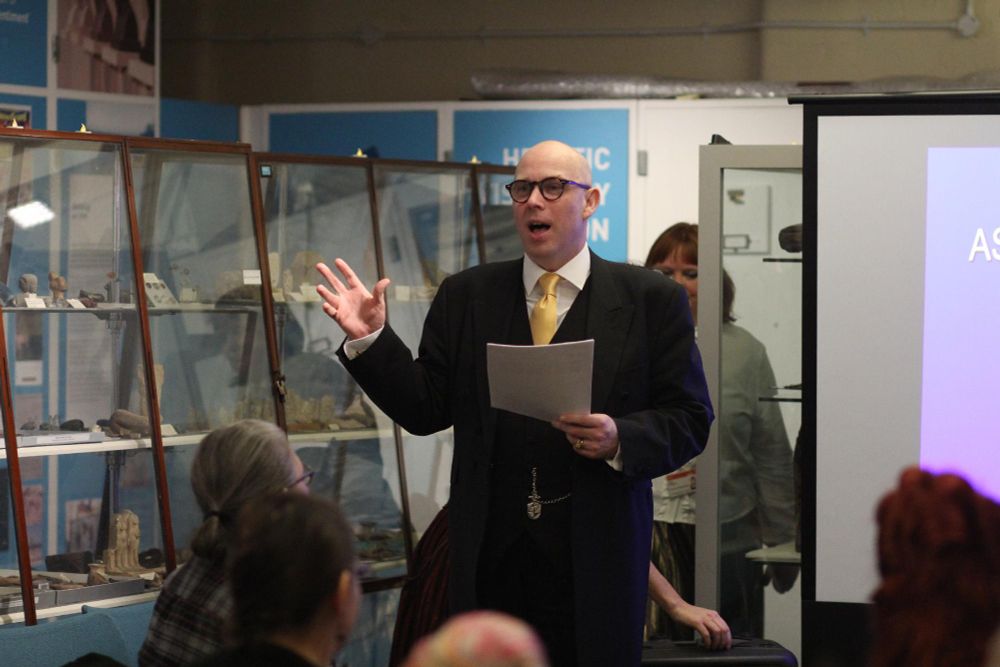 A photograph of John J Johnston giving a lecture at the Petrie Museum. 