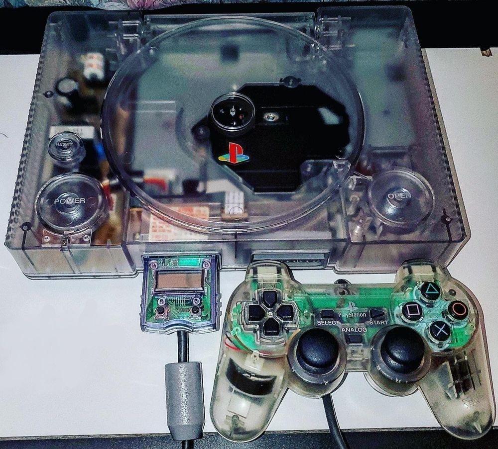 a playstation with a transparent case and transparent controller