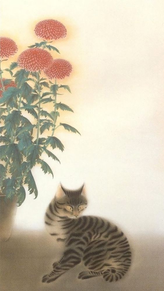 cat crouching by a red Chrysanthemum  plant 