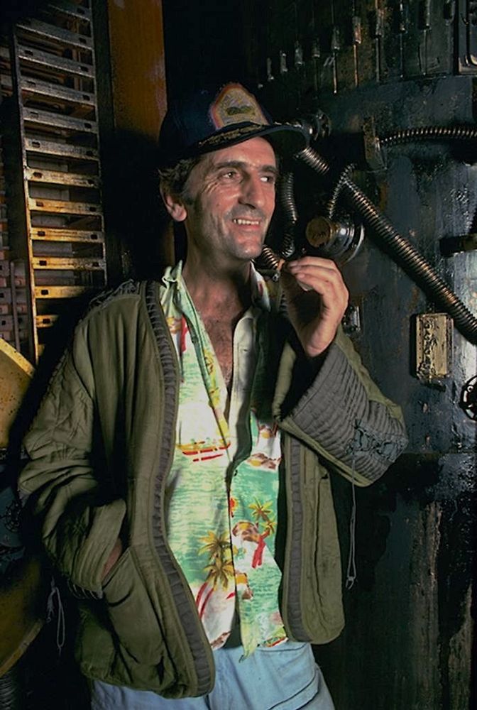candid photo of Harry Dean Stanton smoking a cigarette in costume on the set of 'Alien'