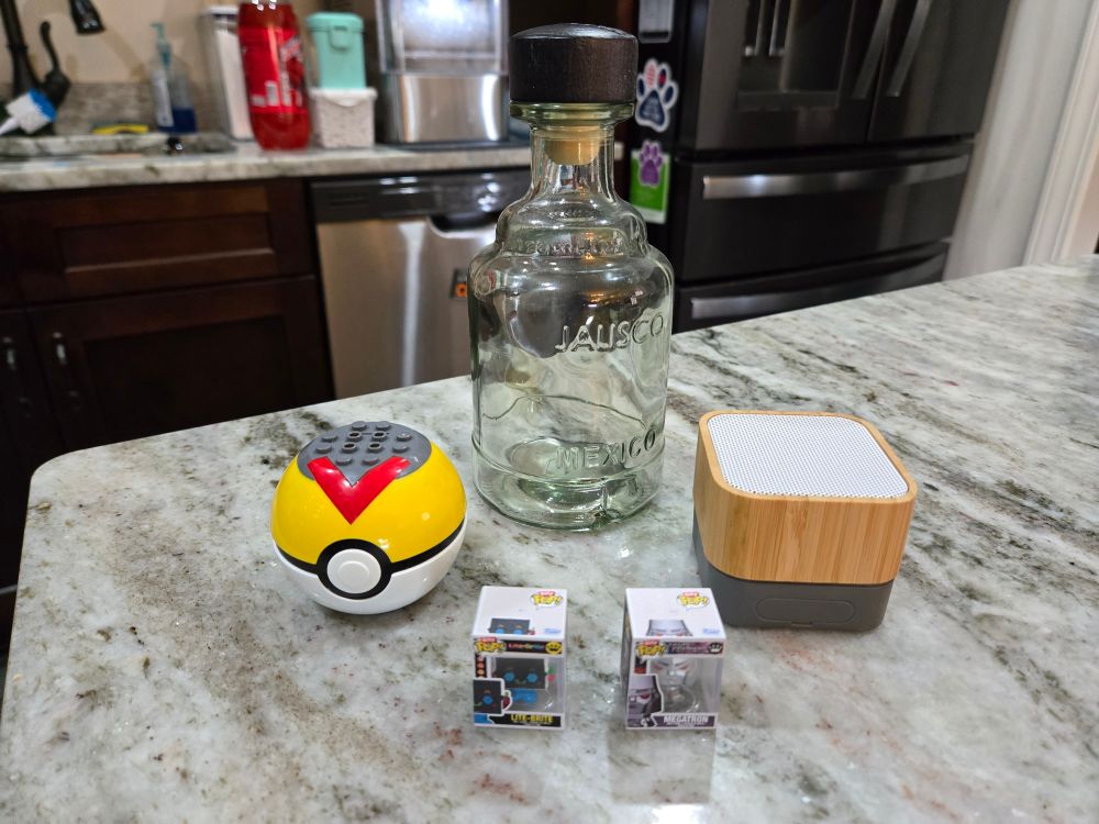 Pokéball, two mini funkos, one empty bottle, one Bluetooth speaker. 