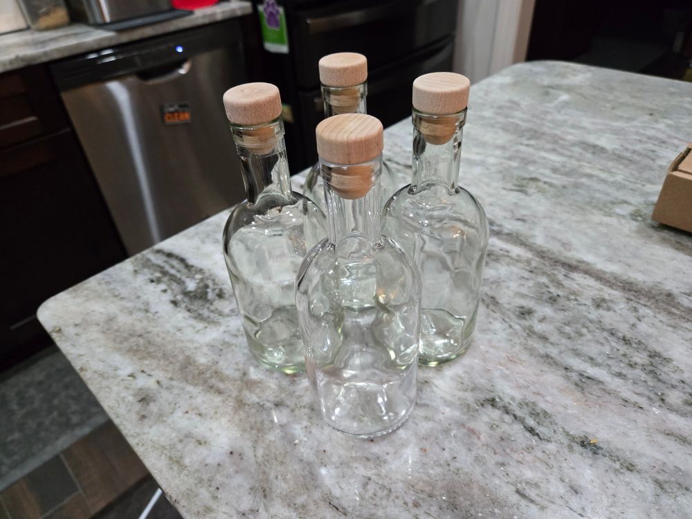 Four glass bottles with corks.