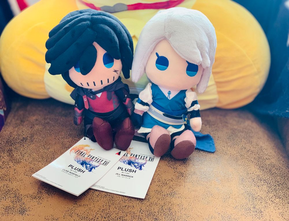 Official square enix plushies of Clive Rosfield and Jill Warrick from Final Fantast XVI sitting on a couch