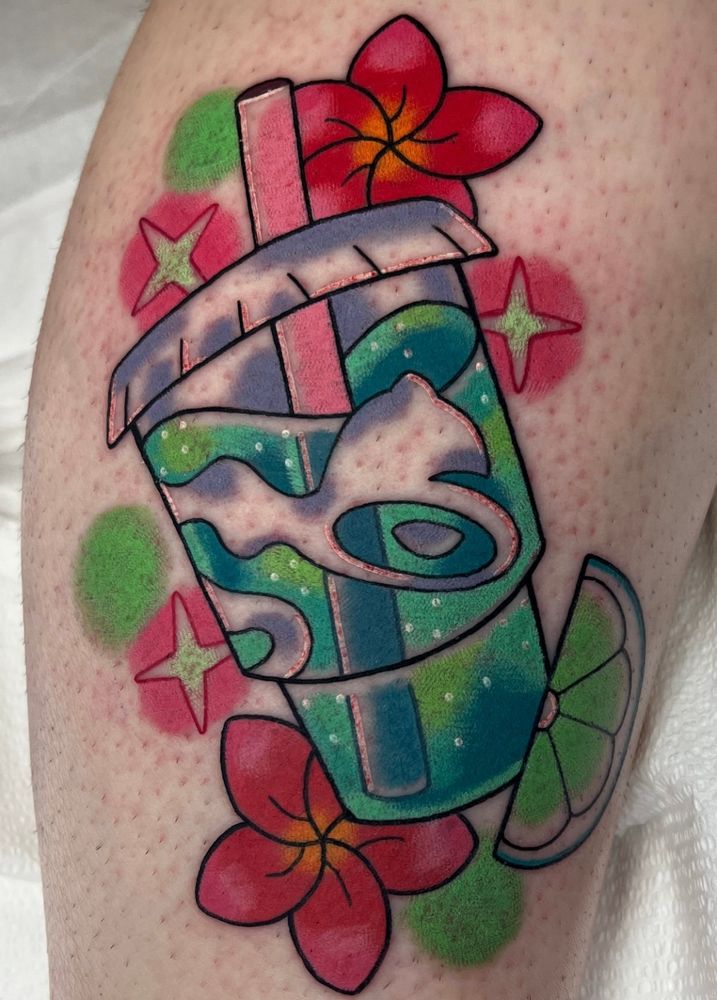 A tattoo of a large cup from taco bell filled with mountain dew Baja blast. The cup is adorned with pink and orange plumeria flowers and a single lime wedge. 