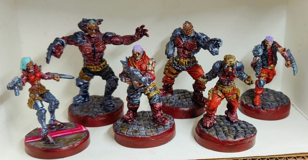 Cyberpunk Combat Zone Maelstrom minis from the core box, painted by Airylan. Front view. They're not very inspiring, being painted silver, copper, reds, browns, and blacks. The sculpts were hard to tell what the details were intended to be, and it shows in the paint job.