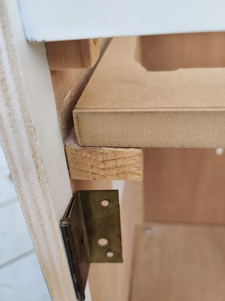 Close up of the monitor mount of a wooden arcade cab aligned with its support (left side)
A hinge is attached just below it.