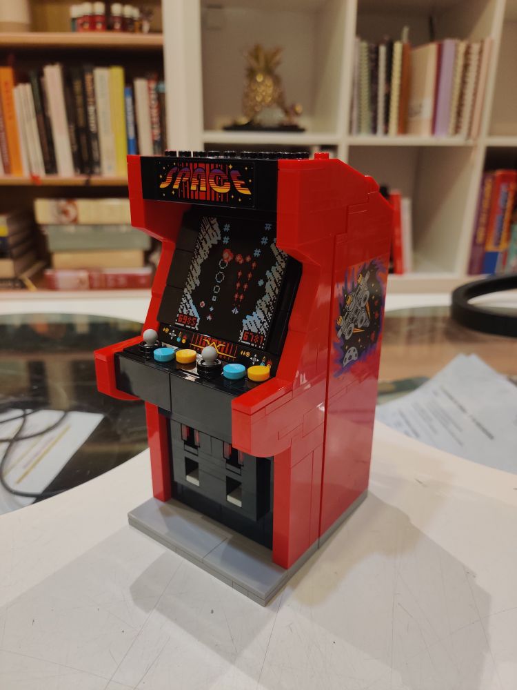 Lego arcade machine set on a table at a 45° angle with a bookshelf in the background.