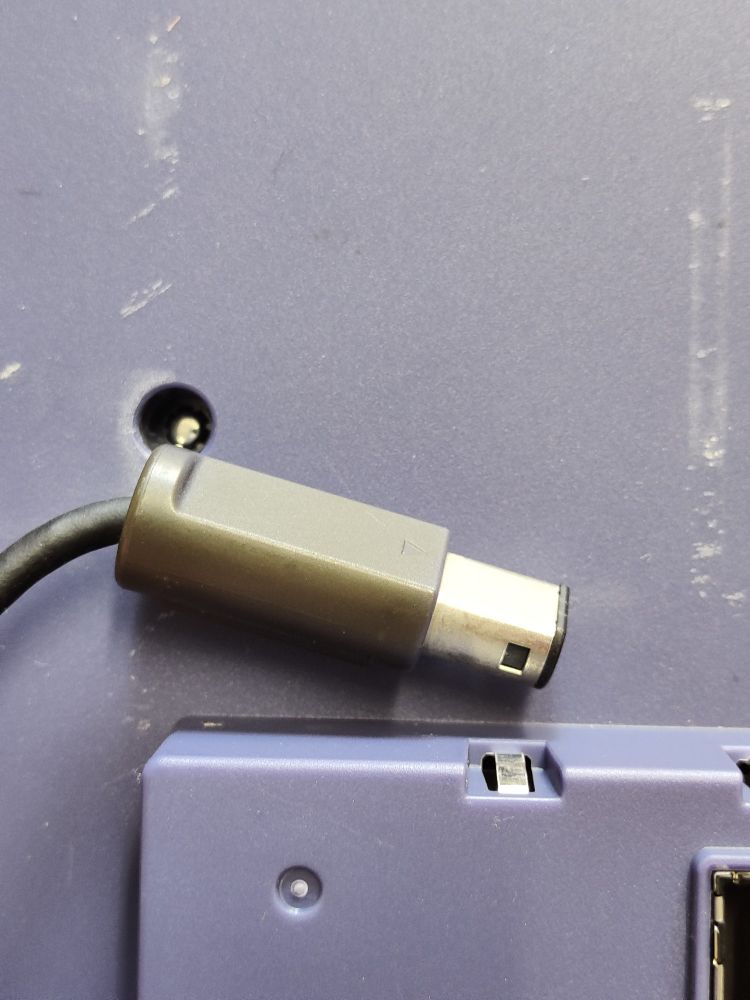 Purple GameCube controller connector on a purple Game Boy Player
Controller plug turned grey in comparison.