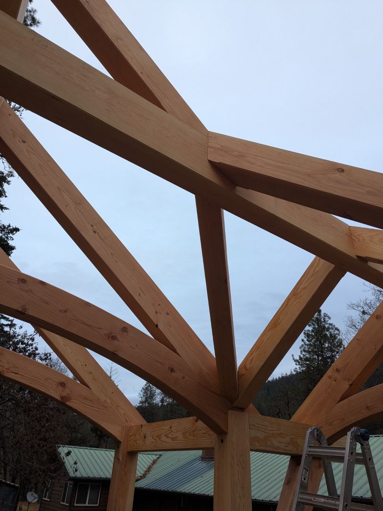 Timber framing detail. Complex roof geometry. Crossing ridge beams, valley rafters, connecting rafters and intersecting common rafters. Pavilion. 