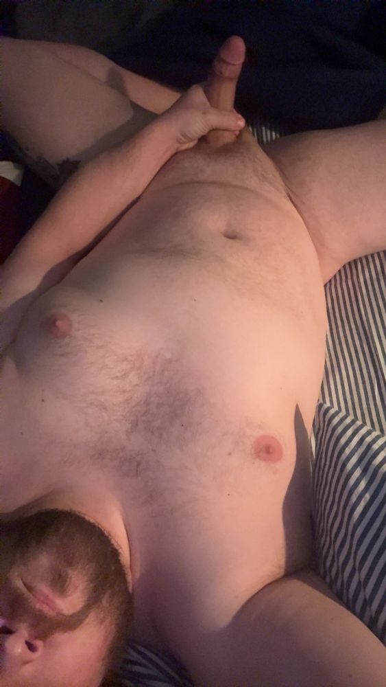 Laying in bed. Downward view showing body and morning wood 