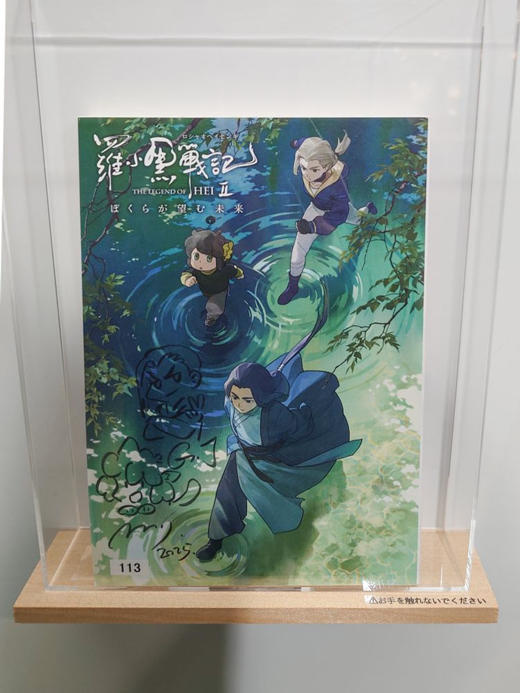 駅構内、映画『羅小黒戦記2』の展示。メインビジュアルにサインとキャラクターの落書き。