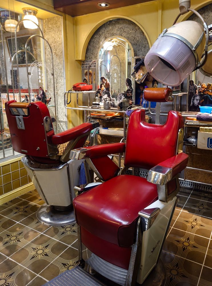 映画『トワイライト・ウォリアーズ』九龍城寨公園の展示写真。龍捲風の理髪店。赤いバーバーチェア。