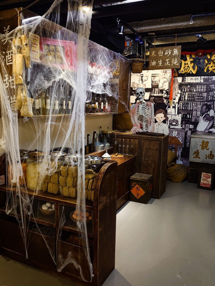 香港の歴史資料館、美荷楼生活館の展示写真。70年代〜90年代の漢方茶屋の展示。飴色の木の調度品、茶葉や漢方の入った瓶が並んでいる。